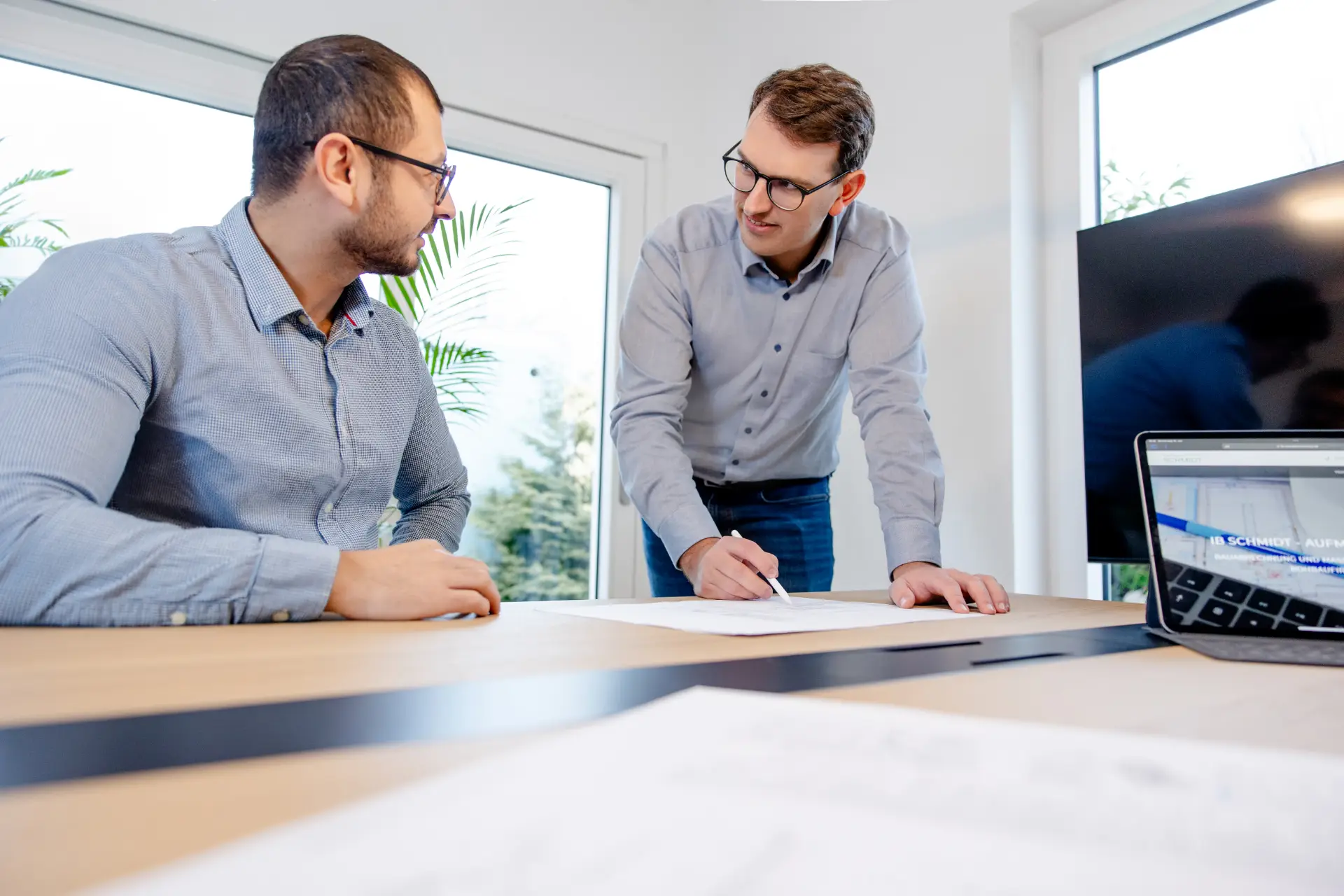 Arbeiten bei IB Schmidt: Besprechung eines Bauplans im Büro